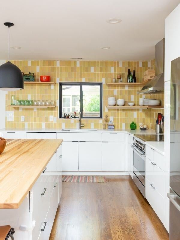 Bright and open kitchen with yellow tile and wood island, part of a renovation by Craft Design + Build, Essex, Connecticut