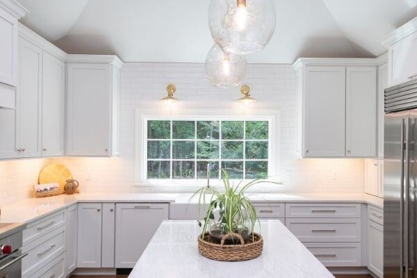 Bright kitchen with large window and island in a South Raleigh home remodel by Craft Design + Build