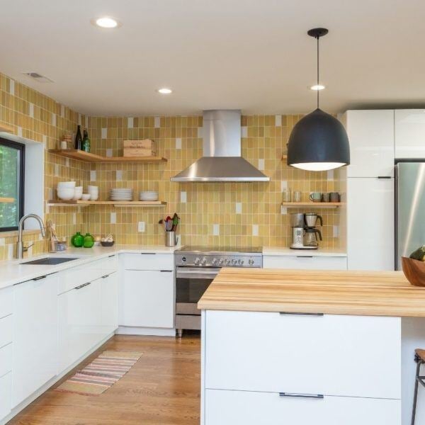 Bright kitchen with yellow tile accents and stainless steel range, remodeled by Craft Design + Build in Essex, Connecticut