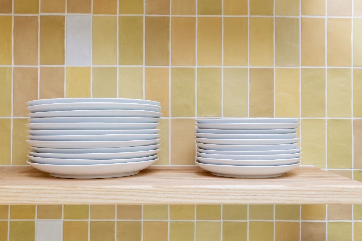 Close-up of stacked plates on a wooden shelf in a remodeled kitchen, Craft Design + Build, Essex, Connecticut