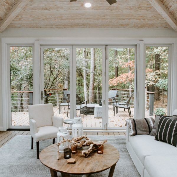 Cozy sunroom with large windows and deck access, designed by Craft Design + Build, Essex, Connecticut