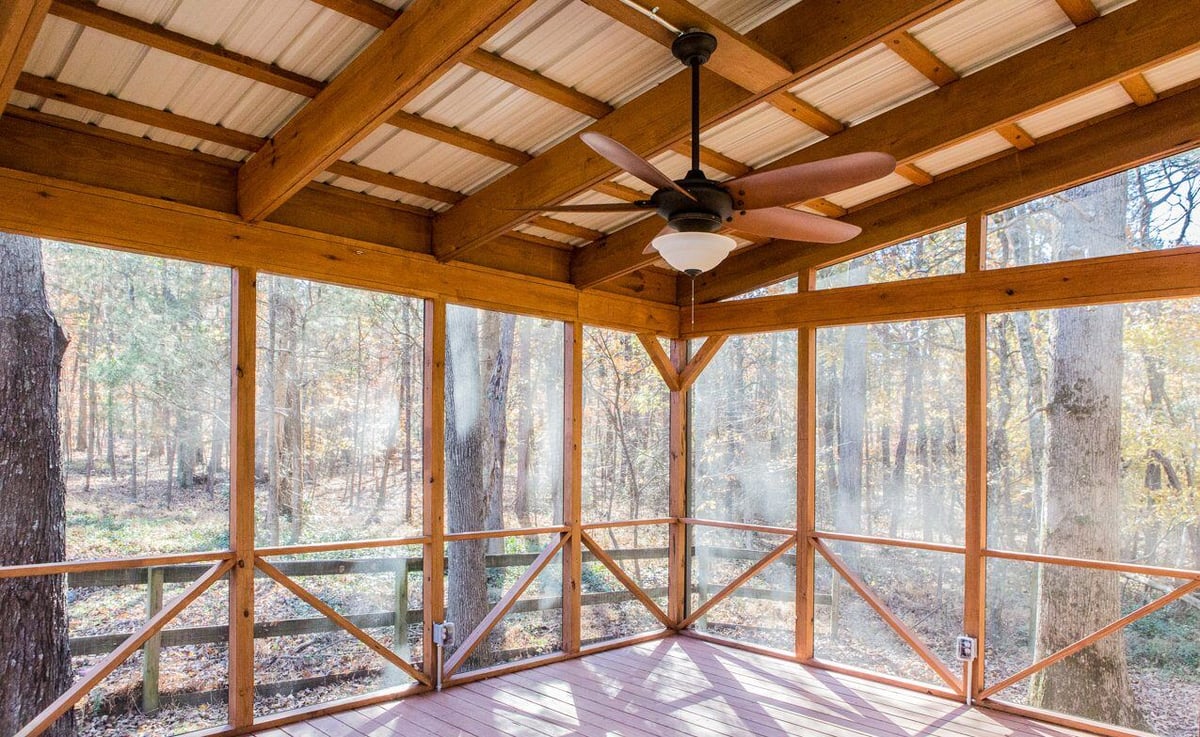 Cozy wooden screened porch with a ceiling fan, crafted by Craft Design + Build in Essex, Connecticut