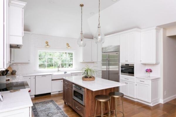 Custom kitchen in Essex, Connecticut by Craft Design + Build, featuring a central island with wood accents and pendant lighting