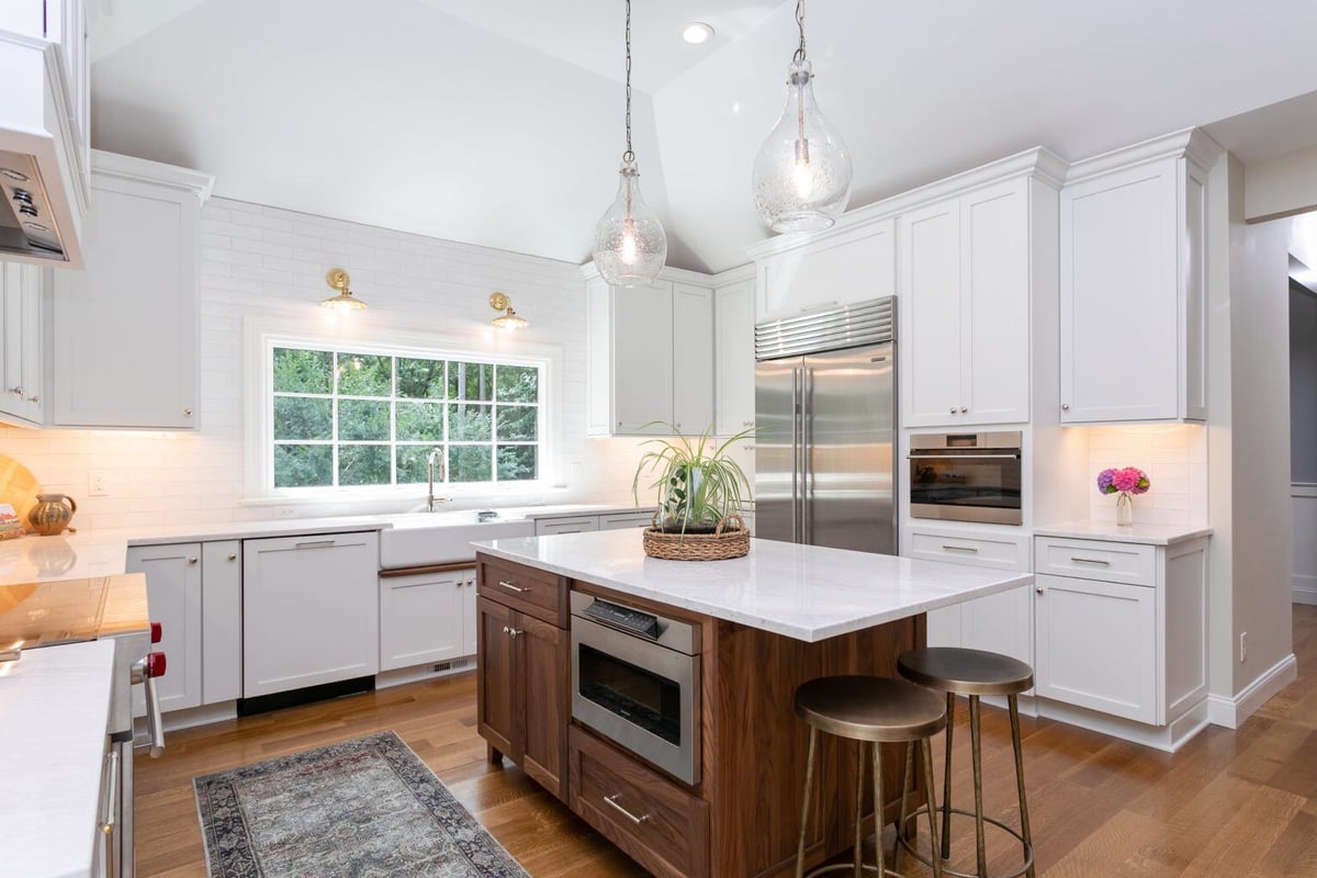 Elegant brass sconce on white tile, part of a kitchen remodel in Essex, Connecticut