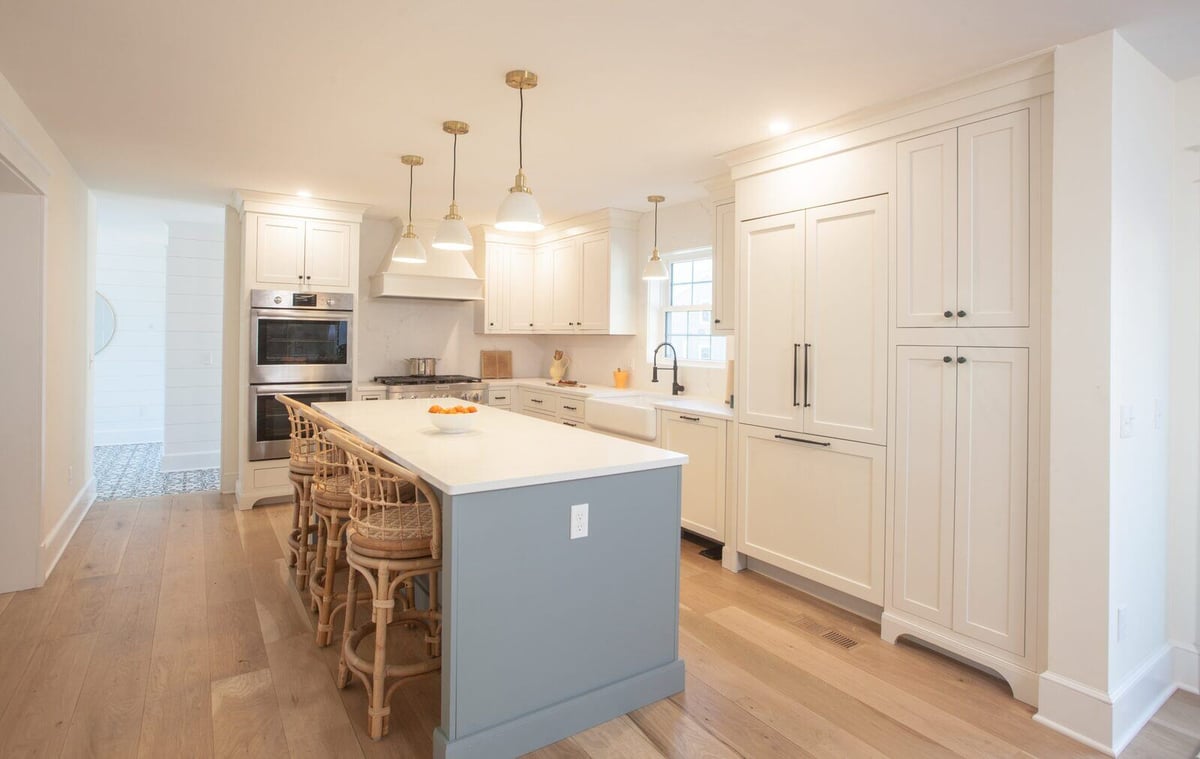 Farmhouse kitchen featuring a large island, white cabinetry, and modern appliances, designed by Craft Design + Build