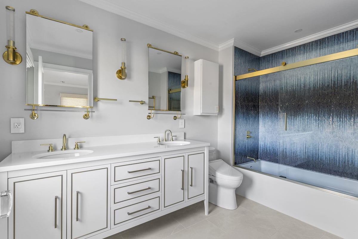 Modern bathroom remodel with dual sinks and gold fixtures by Craft Design Build in Essex, CT