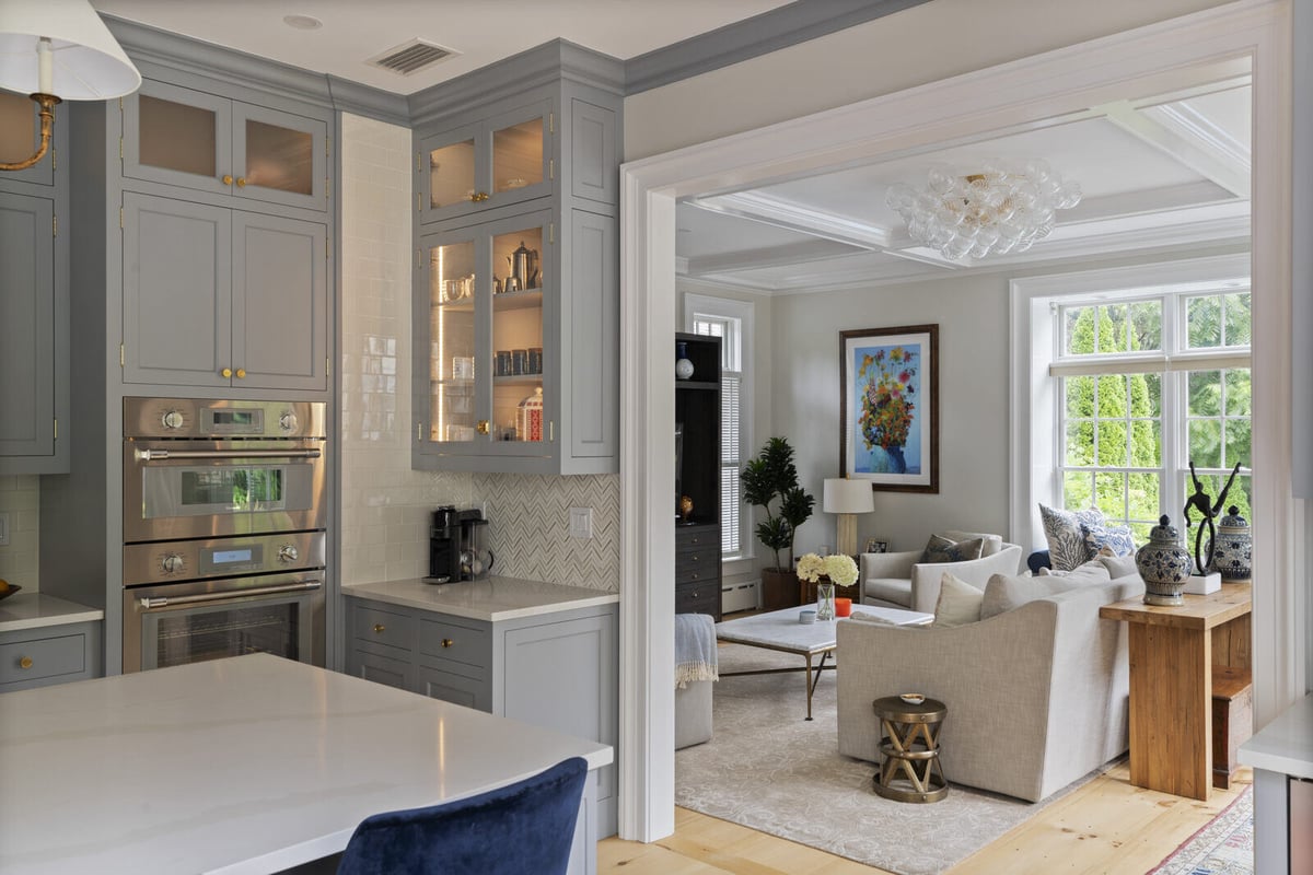 Kitchen and living room remodel by Craft Design and Build in Essex, Connecticut featuring grey cabinets and a cozy living area