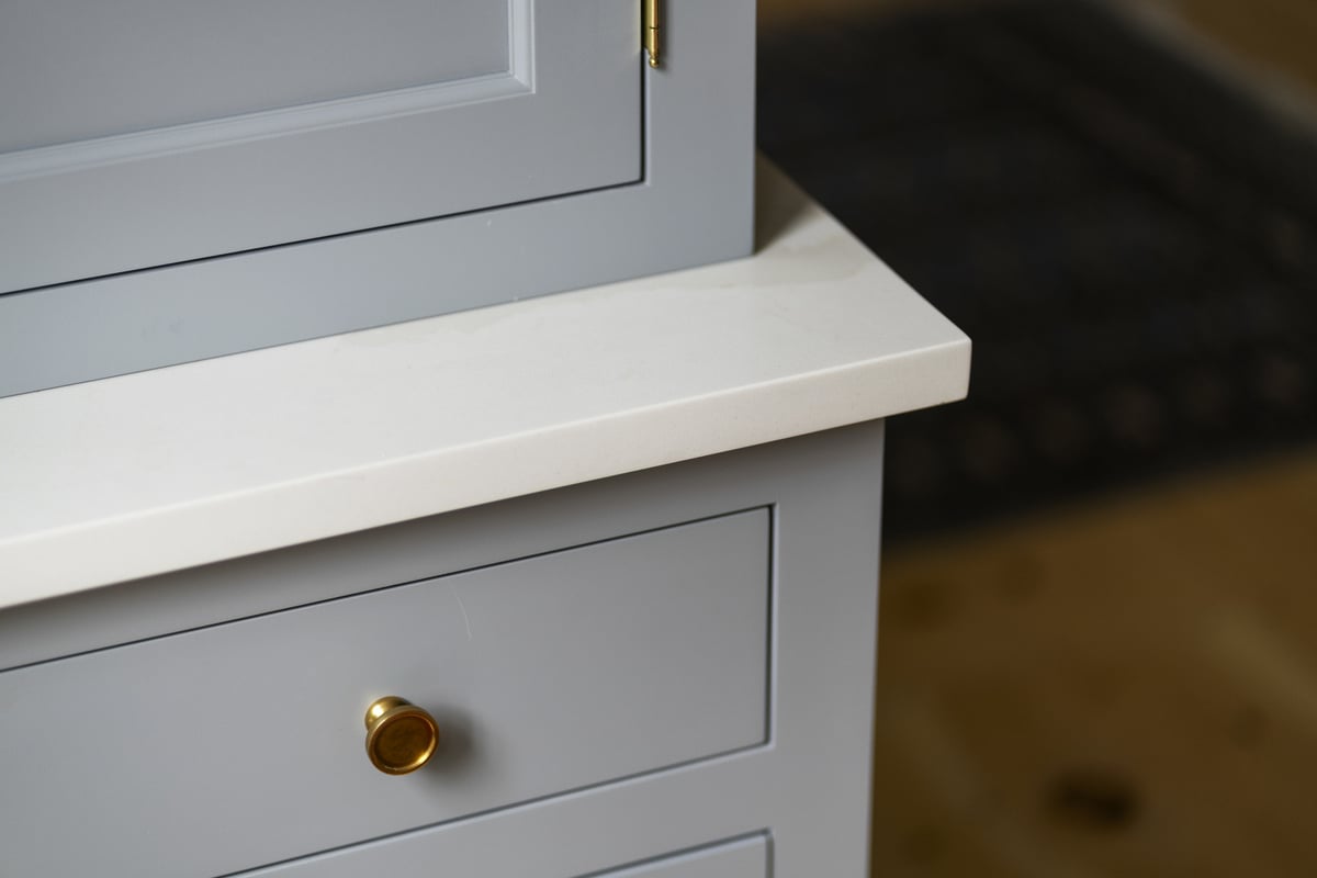 Kitchen counter with grey cabinets and gold handles, designed by Craft Design and Build in Essex, Connecticut