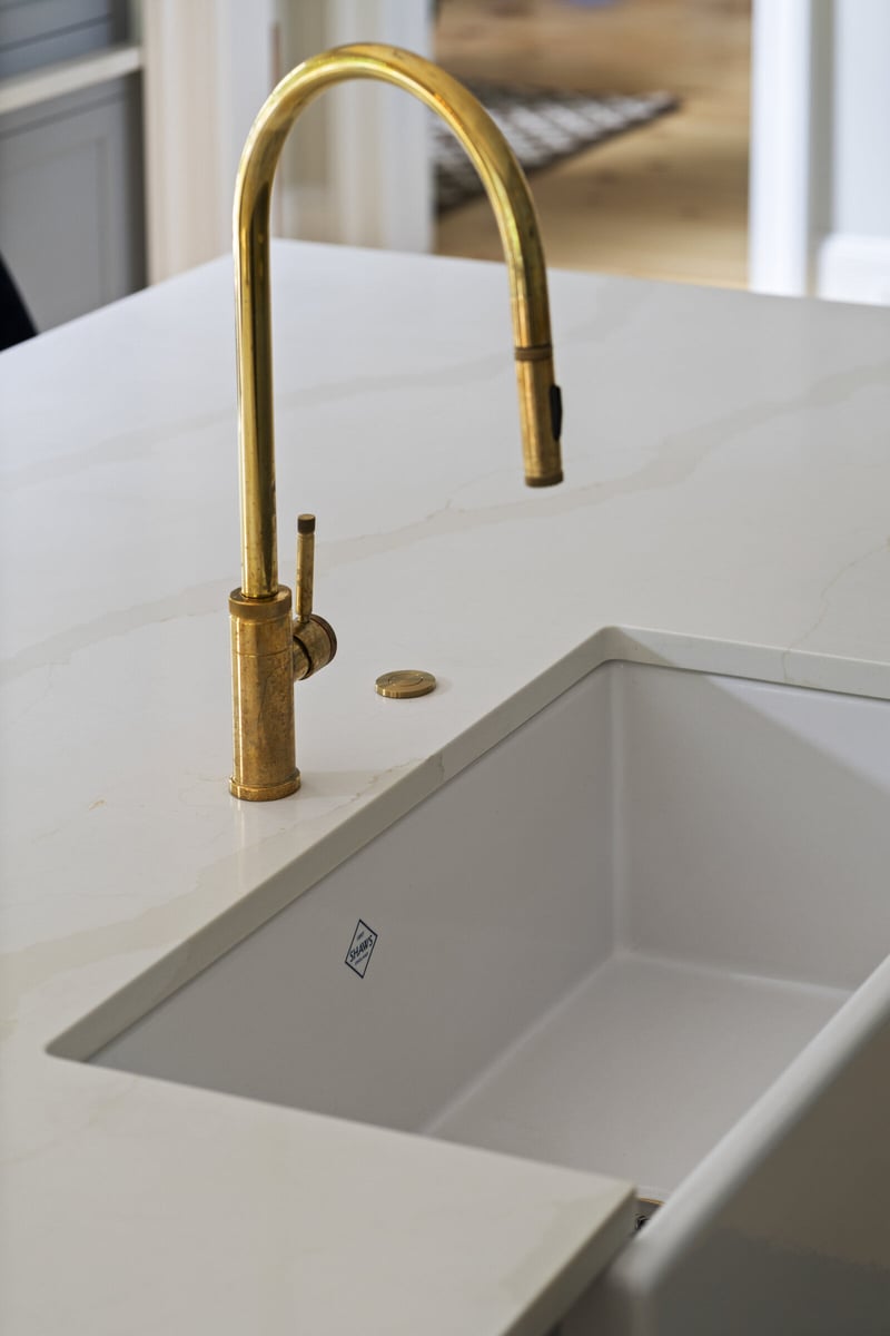 Kitchen island with gold faucet in a modern remodel by Craft Design and Build in Essex, Connecticut