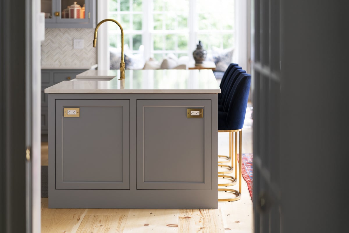 Kitchen island with grey cabinetry and gold fixtures, designed by Craft Design and Build in Essex, Connecticut