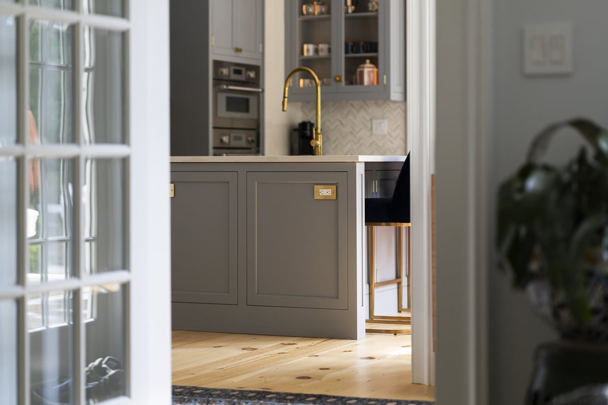 Kitchen island with seating and gold faucet, remodeled by Craft Design and Build in Essex, Connecticut