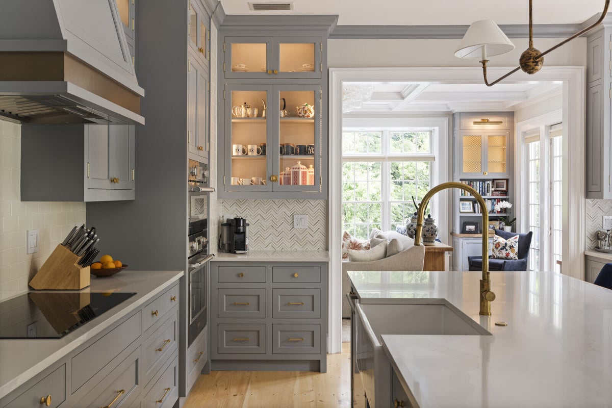 Kitchen remodel by Craft Design and Build in Essex, Connecticut featuring grey cabinets and a gold faucet