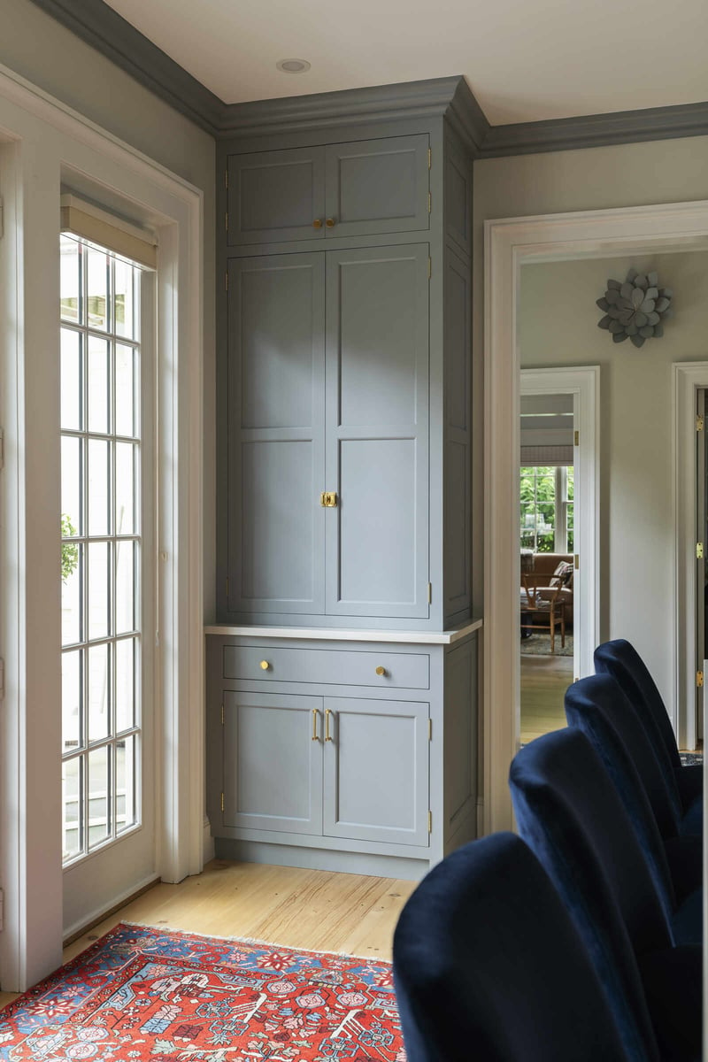 Living area with French doors and built-in bookshelves, designed by Craft Design and Build in Essex, Connecticut