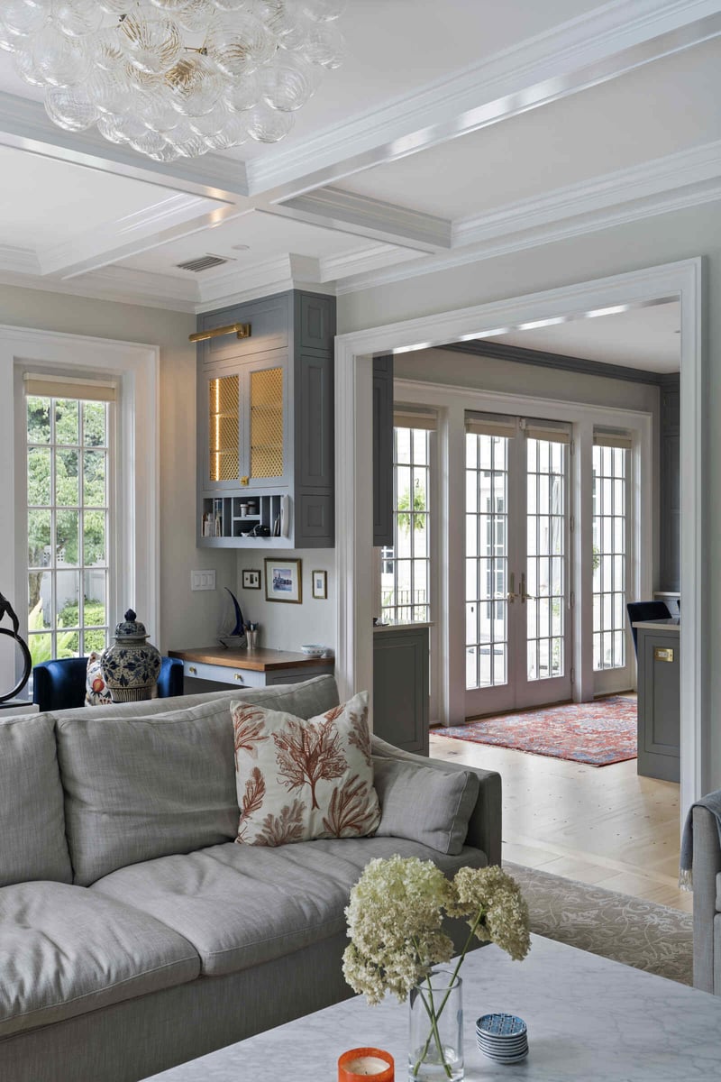 Living room with French doors and a cozy couch, designed by Craft Design and Build in Essex, Connecticut