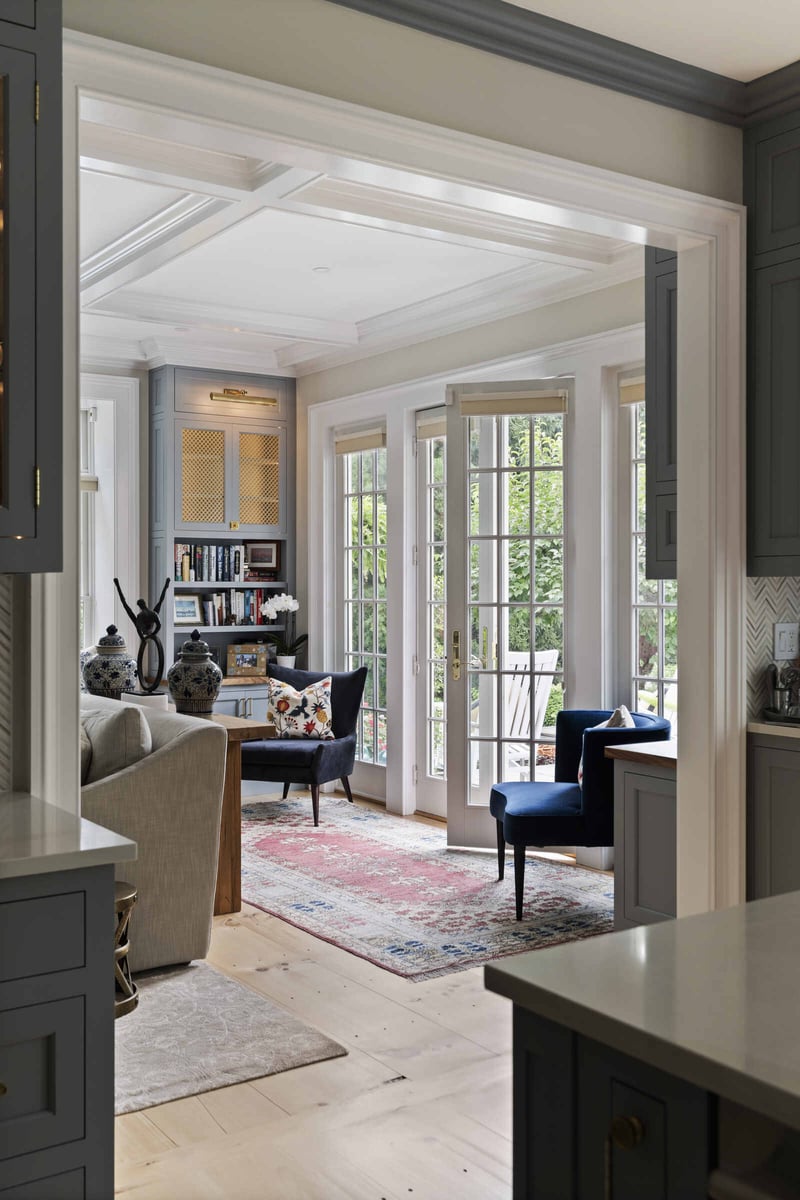 Living room with large windows and built-in seating, designed by Craft Design and Build in Essex, Connecticut