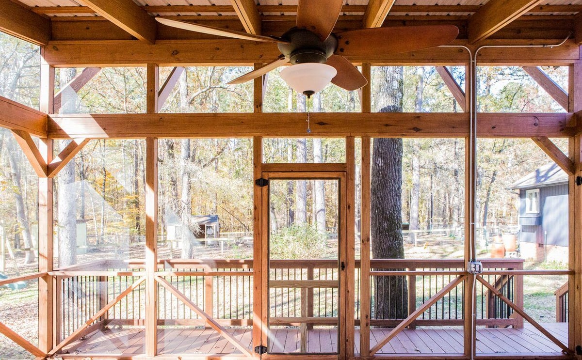 Front view of a wooden screened porch with door and ceiling fan, created by Craft Design + Build in Essex, Connecticut