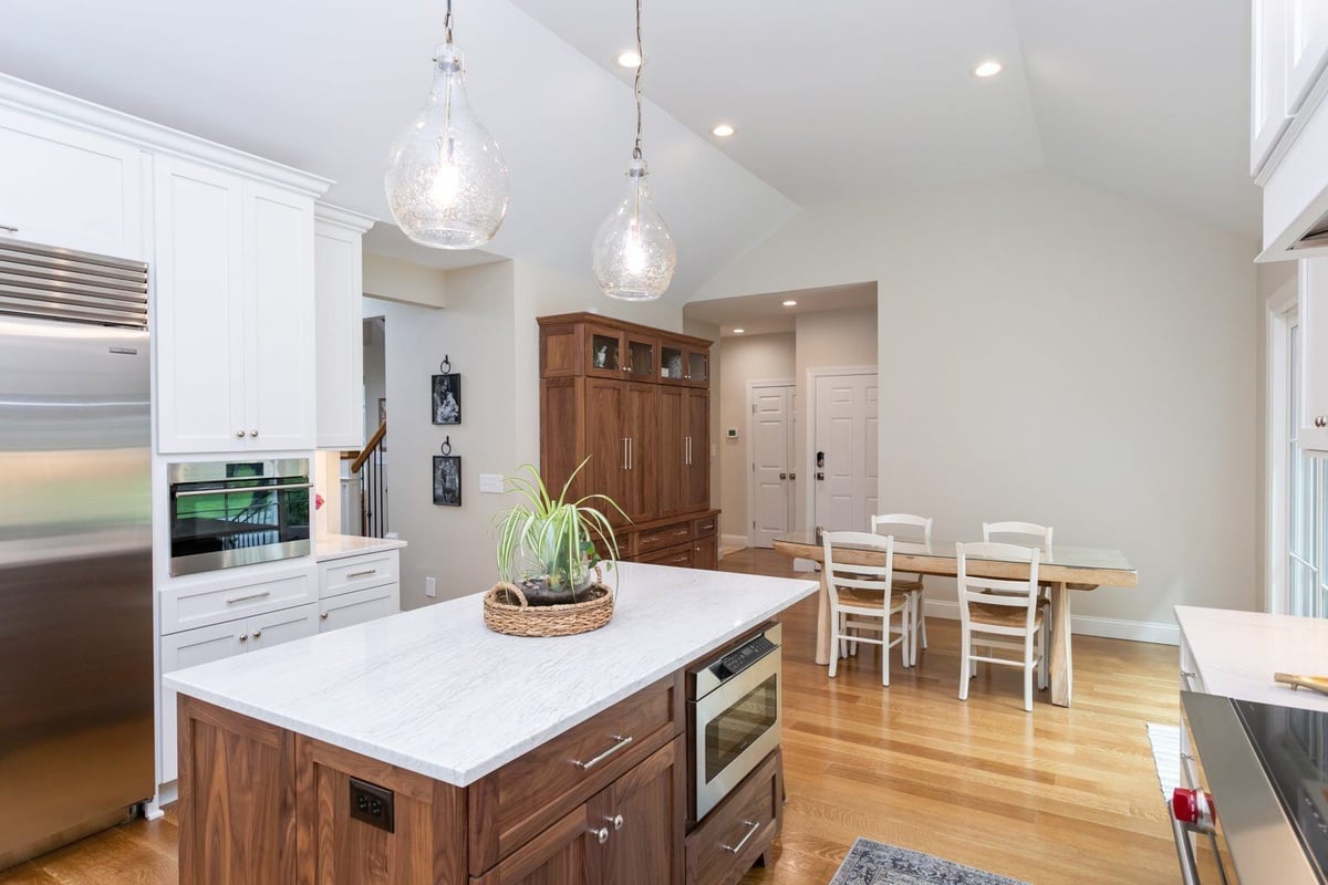 Full view of a transitional kitchen with white cabinetry, a central island, and large windows in Essex, Connecticut