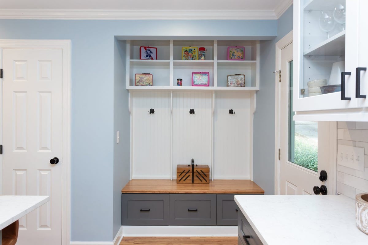 Functional entryway storage unit with hooks and bench in Essex home remodel by Craft Design + Build