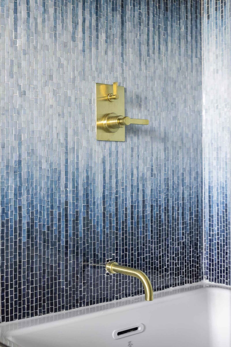 Gold shower control against a blue mosaic tile wall in an Essex bathroom remodel by Craft Design + Build, Essex Connecticut