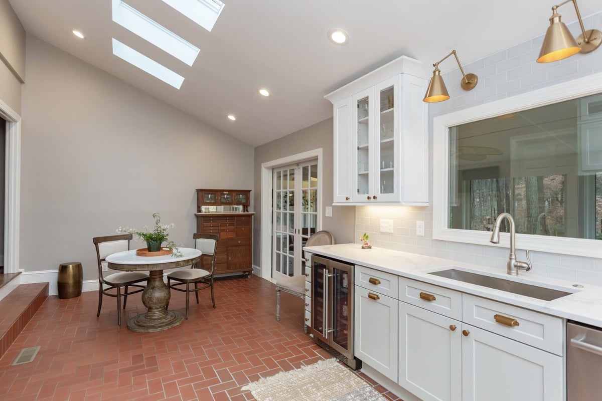 Hallway with brick flooring and white doors leading to the kitchen in a home renovation in Essex by Craft Design + Build