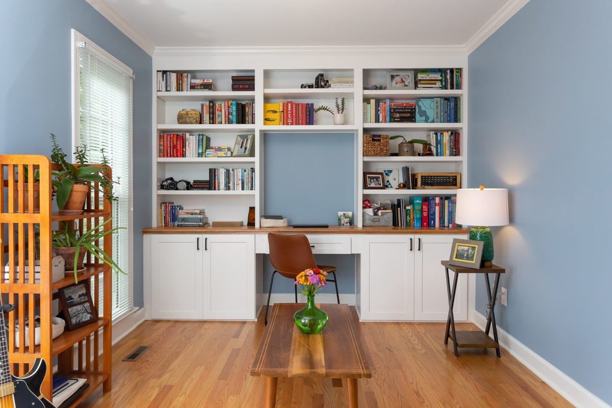 Home office with built-in bookshelves and desk in a remodeled Essex home by Craft Design + Build