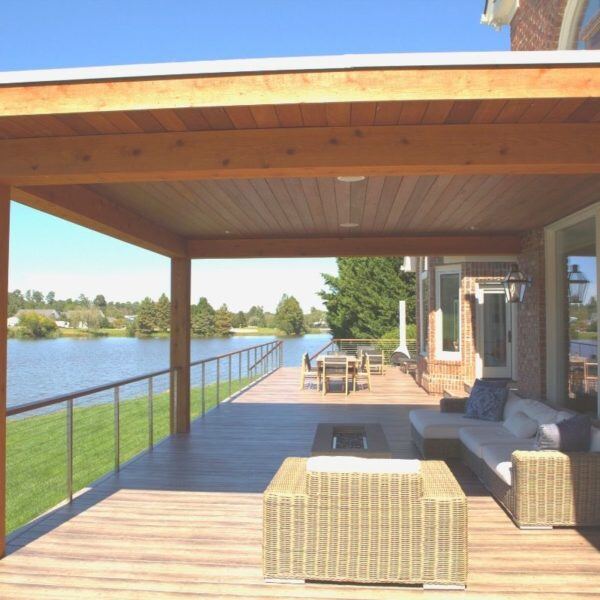 Lakefront patio deck remodel with wooden ceiling and modern furniture by Craft Design + Build, Essex, Connecticut