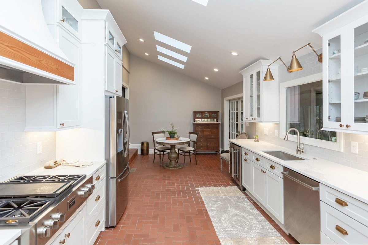 Modern kitchen and dining space with white cabinetry and skylights in Essex, Connecticut