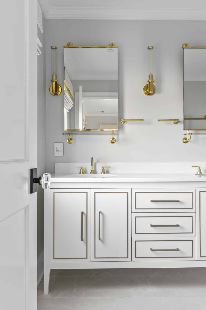 Modern white bathroom vanity with gold fixtures in an Essex home remodel by Craft Design + Build, Essex Connecticut