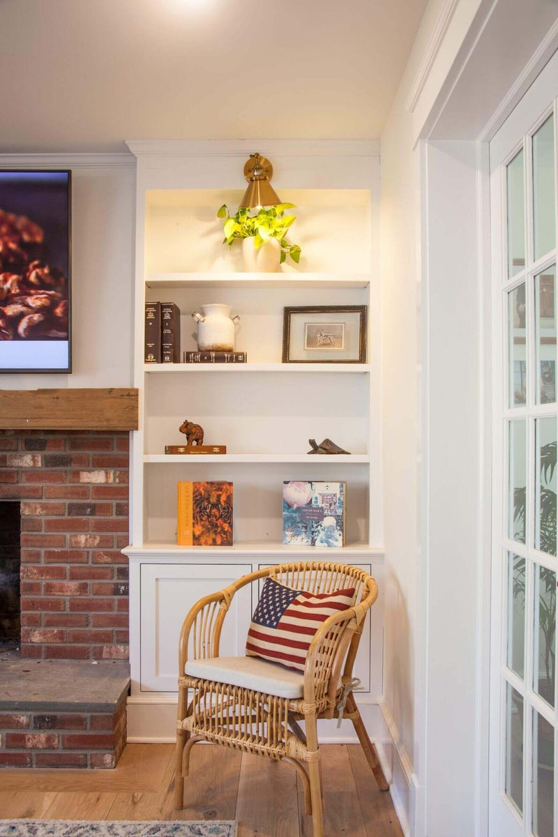 Mudroom featuring shiplap walls, built-in shelving, and a window bringing in natural light, with black and white floor tiles