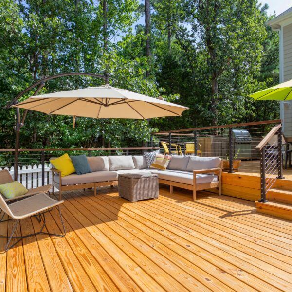 Outdoor deck with modern seating and umbrella, part of a custom home renovation by Craft Design + Build, Essex, Connecticut