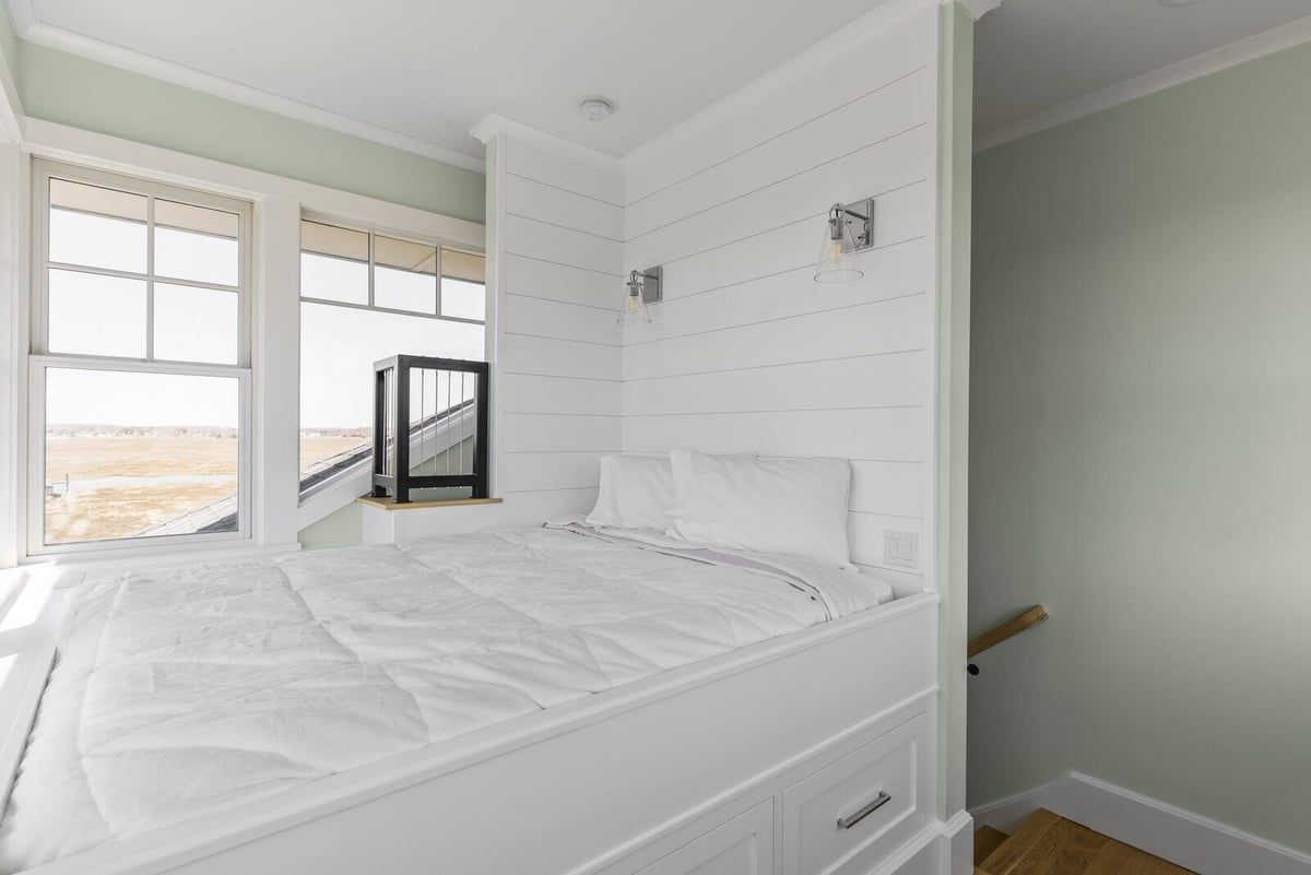 Renovated bedroom with a custom white bed and shiplap accents in Essex, Connecticut by Craft Design + Build-1