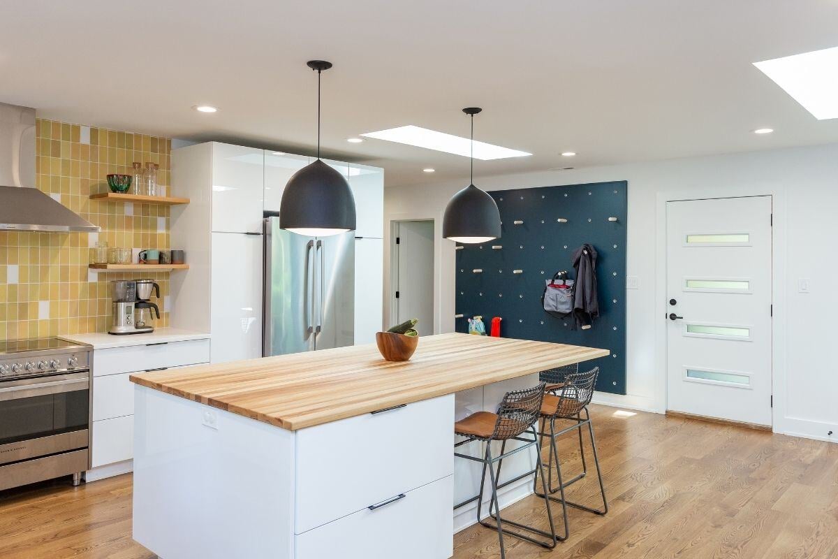 Renovated kitchen with island and pegboard wall, custom project by Craft Design + Build, Essex