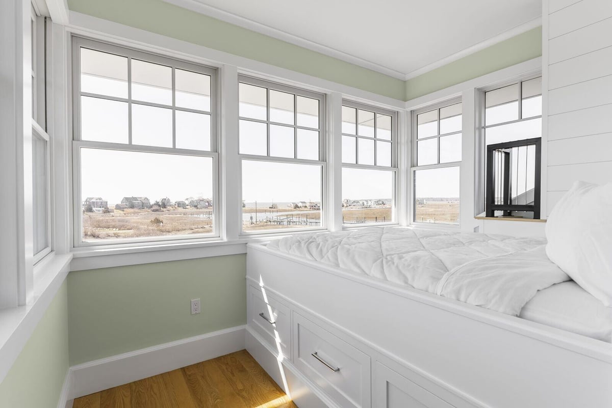 Scenic bedroom featuring a custom white bed with built-in storage drawers by Craft Design + Build in Essex, Connecticut