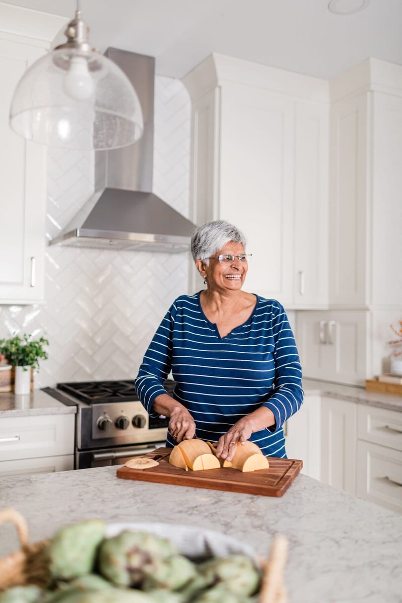 Senior woman preparing food in remodeled Essex, Connecticut kitchen by Craft Design + Build