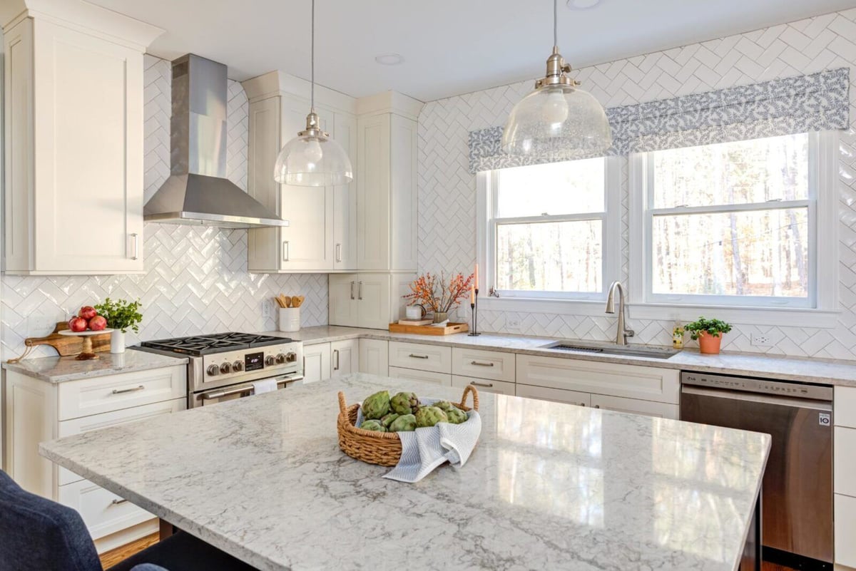 Spacious kitchen with large island and stainless steel range in Essex, Connecticut by Craft Design + Build