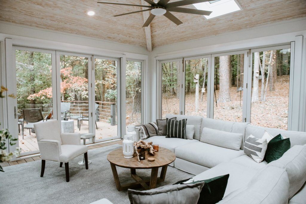 Stylish 4 seasons room with panoramic windows overlooking a wooded backyard, designed by Craft Design + Build in Essex, Connect