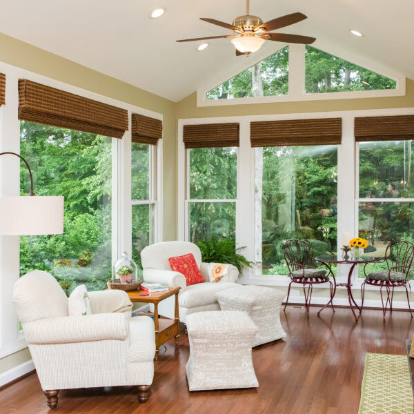 Sunlit sunroom with high ceilings and lush garden views, remodeled by Craft Design + Build, Essex, Connecticut