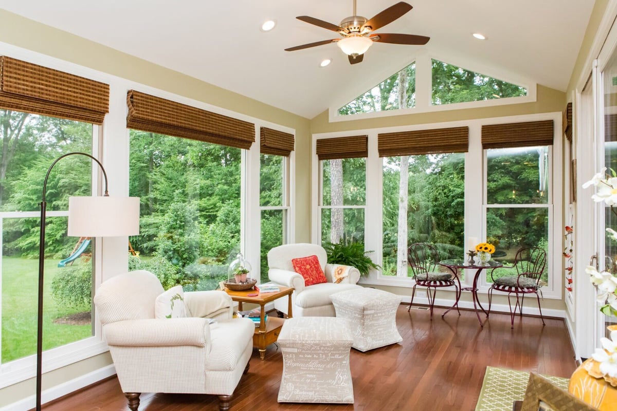 Sunroom with large windows and cozy seating in a custom Essex, Connecticut home